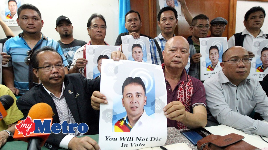 DUSIT (duduk kiri) bersama Presiden Kongres Kebangsaan Dayak (DNC), Mengga Mikui (duduk dua kanan)  dan ahli Persatuan Dayak Sarawak memegang poster Bill Kayong yang mati ditembak. FOTO Che Rani Din