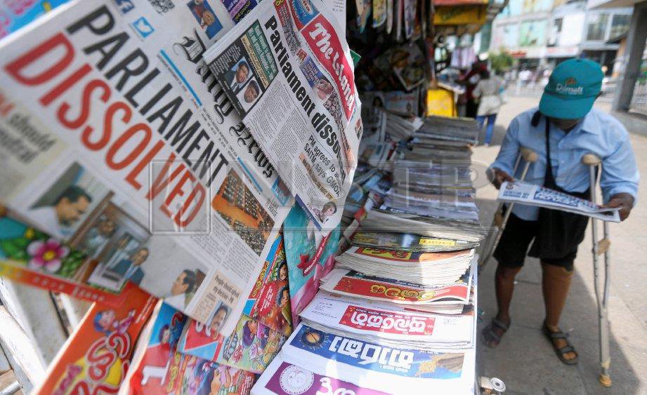 Seorang lelaki rakyat Sri Lanka membaca surat khabar yang mengandungi berita pembubaran Parlimen Sri Lanka, di Colombo. FOTO Reuters