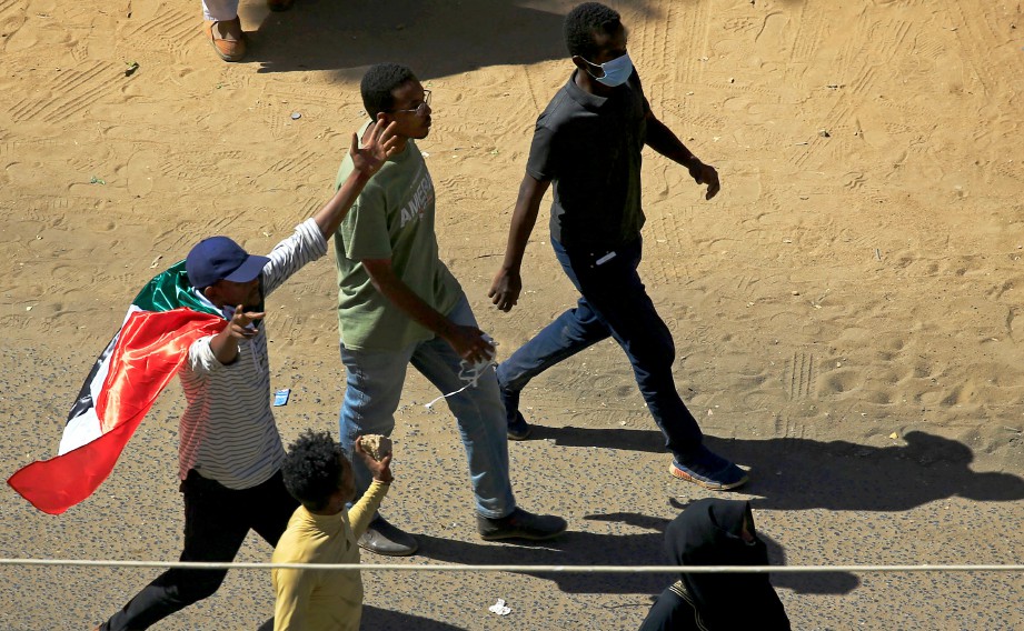 PENUNJUK perasaan menerbangkan bendera negara ketika mereka menyanyikan slogan semasa protes menuntut Presiden Sudan Omar Al-Bashir untuk mundur di Khartoum. FOTO REUTERS