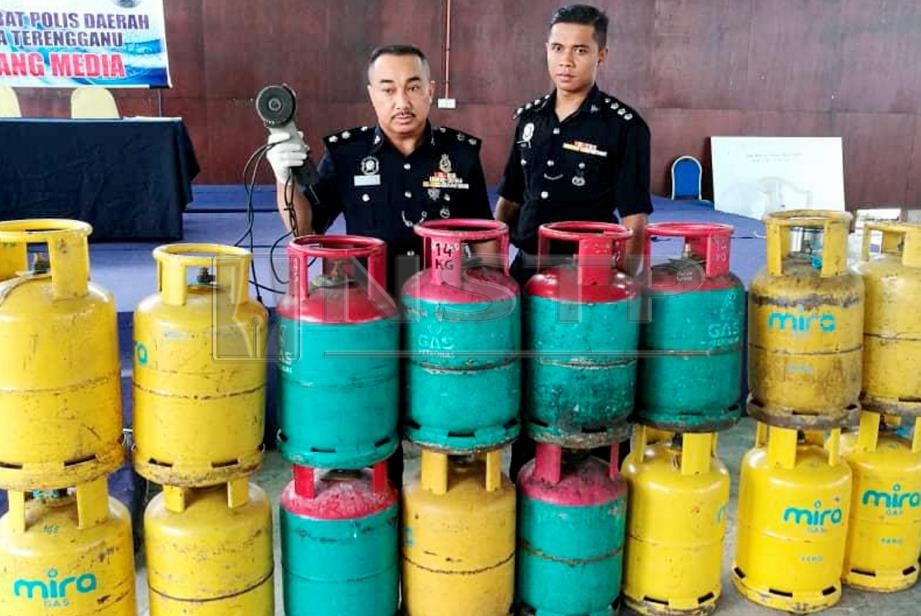 SUFFIAN (kiri) menunjukkan tong gas dirampas susulan penahanan seorang lelaki yang memecah masuk premis untuk mencuri tong gas di sekitar Kuala Terengganu pada sidang media di IPD Kuala Terengganu, semalam. FOTO Zatul Iffah Zolkiply.