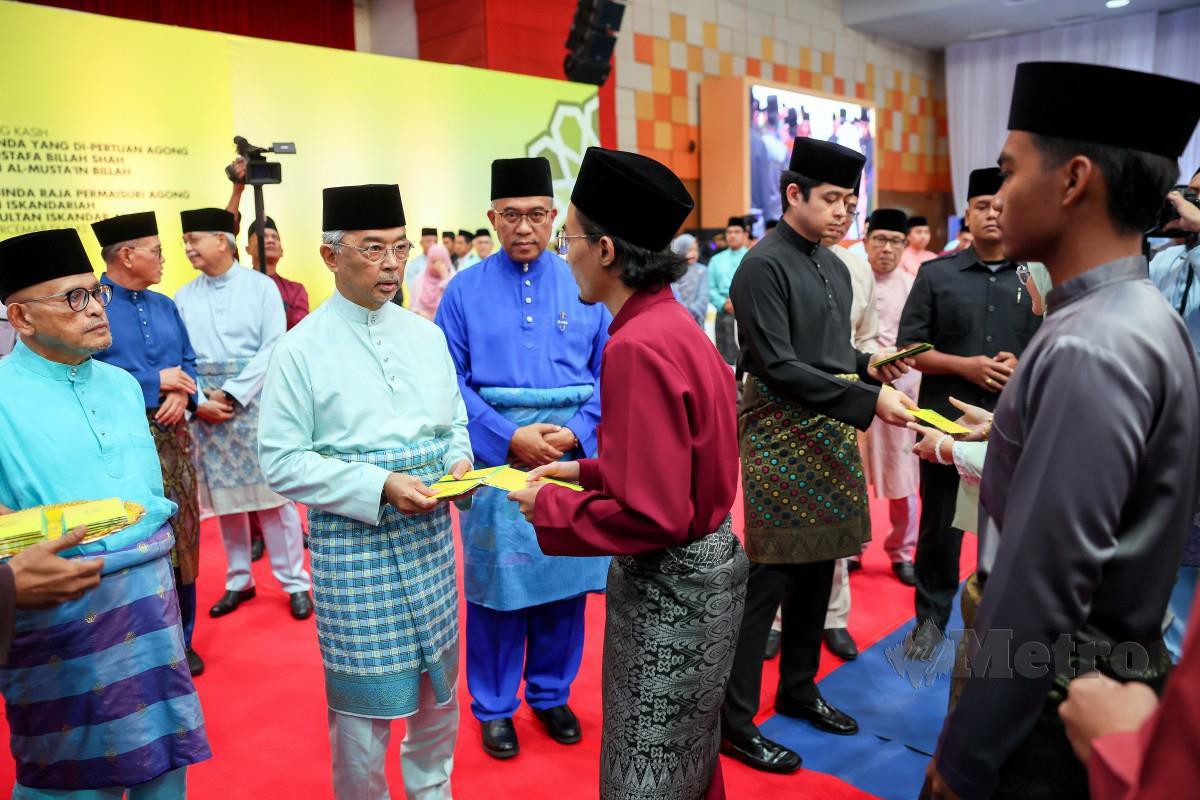 AL-SULTAN Abdullah dan Tengku Hassanal Ibrahim Alam Shah berkenan mengurniakan sumbangan kepada pelajar pada Majlis Berbuka Puasa Bersama Warga UMP. FOTO Bernama 