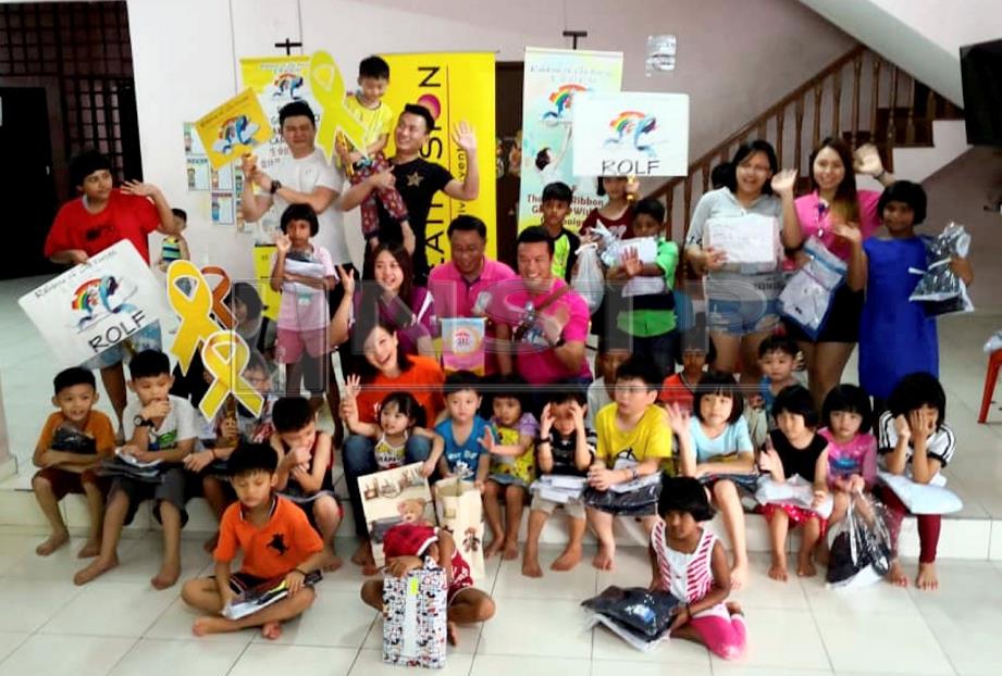 Exco Pembangunan Wanita dan Pelancongan Johor, Liow Cai Tung (duduk, tengah) bergambar bersama kanak-kanak yang menerima sumbangan serta sukarelawan ROLF di Johor Bahru. Foto : IZLAILY NURUL AIN HUSSEIN