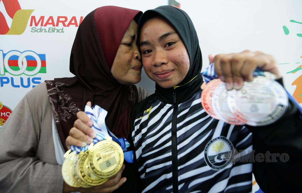 SYAHIDA Asyiqin  menerima ciuman tahniah dari ibunya, Rabidah Said, 57 selepas meraih empat emas.  FOTO Mohd Fadli Hamzah