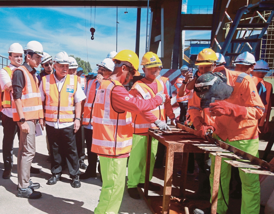 SYED  Saddiq (kiri) bersama Dell Akbar (dua dari  kiri) melihat ODS yang bekerja dalam industri  di LRT 3 Casting Yard di  Bandar Saujana Putra. 