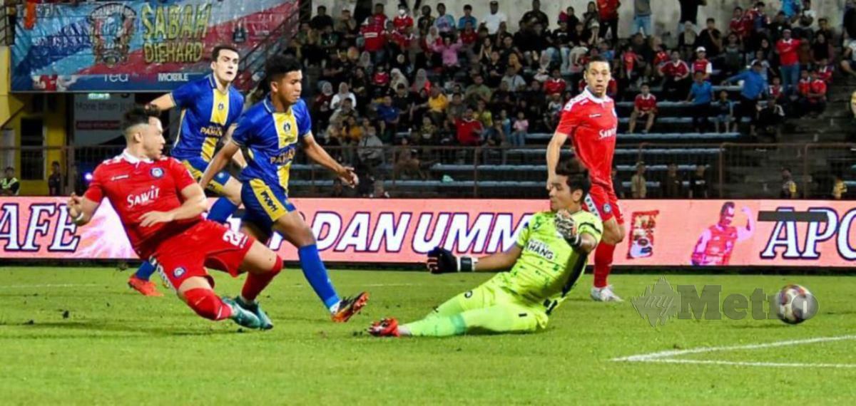 DARREN (kiri) menjaringkan gol pertama pasukannya menewaskan penjaga gol Sri Pahang FC, Muhammad Zarif Irfan (kanan) dalam aksi Liga Super di Stadium Likas. FOTO MOHD ADAM ARININ