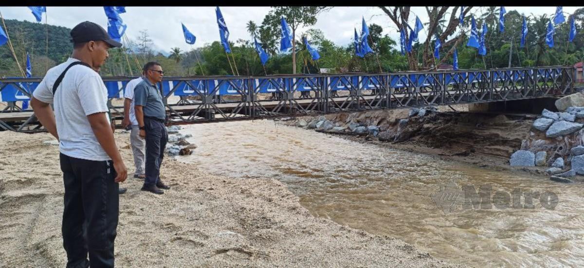 PENDUDUK melihat tebing Sungai Kupang di Kampung Iboi semakin runtuh akibat hujan lebat dan banjir kilat. FOTO Safuri Kamarudin