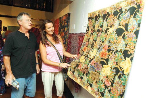 PELANCONG dari England tertarik dengan keunikan batik kapas dipamerkan di Muzium Tekstil Negara.