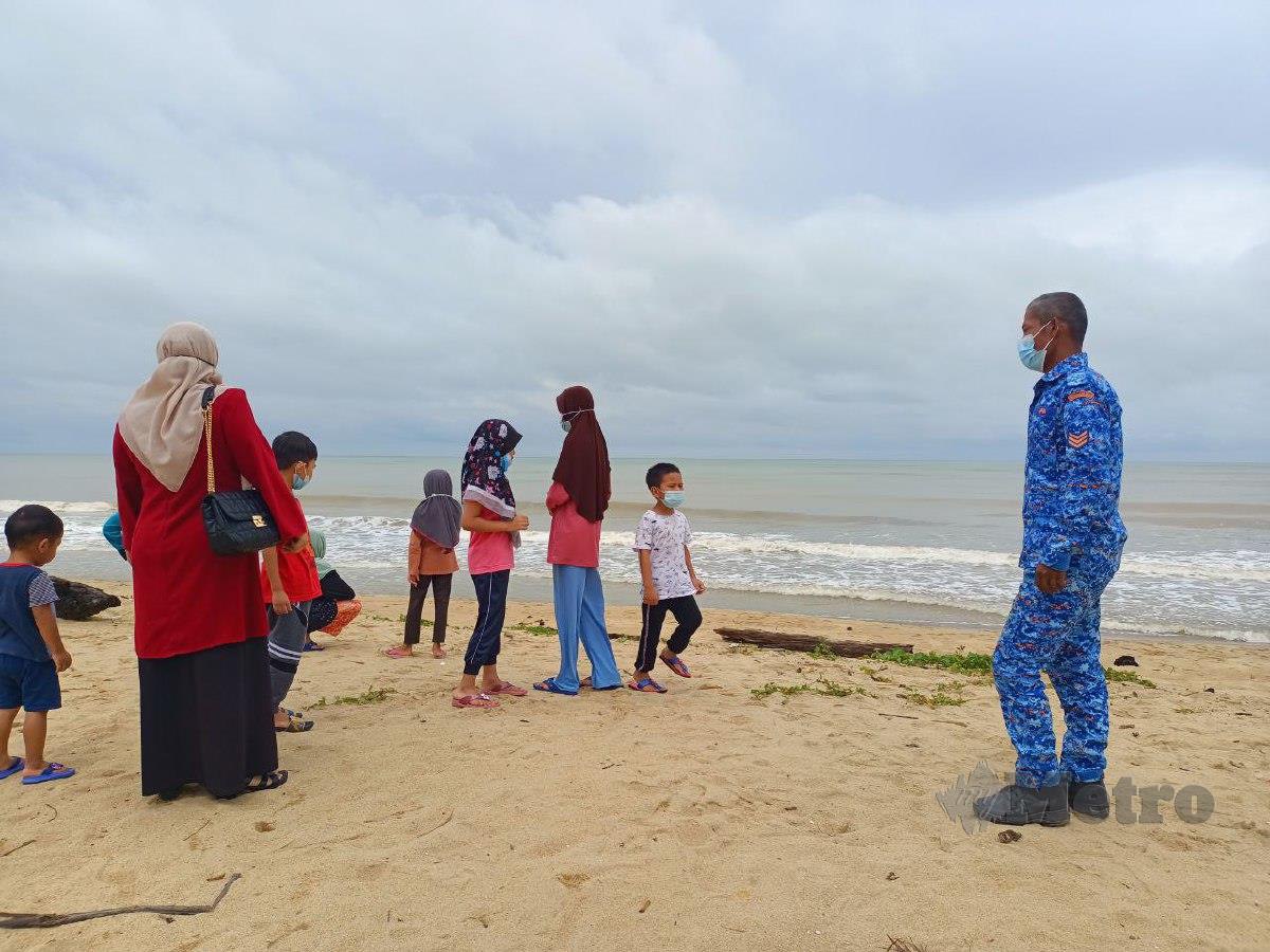 ANGGOTA APM menasihatkan pengunjung agar tidak terlalu menghampiri pantai berikutan amaran dikeluarkan Jabatan Meteorologi. FOTO Siti Rohana Idris