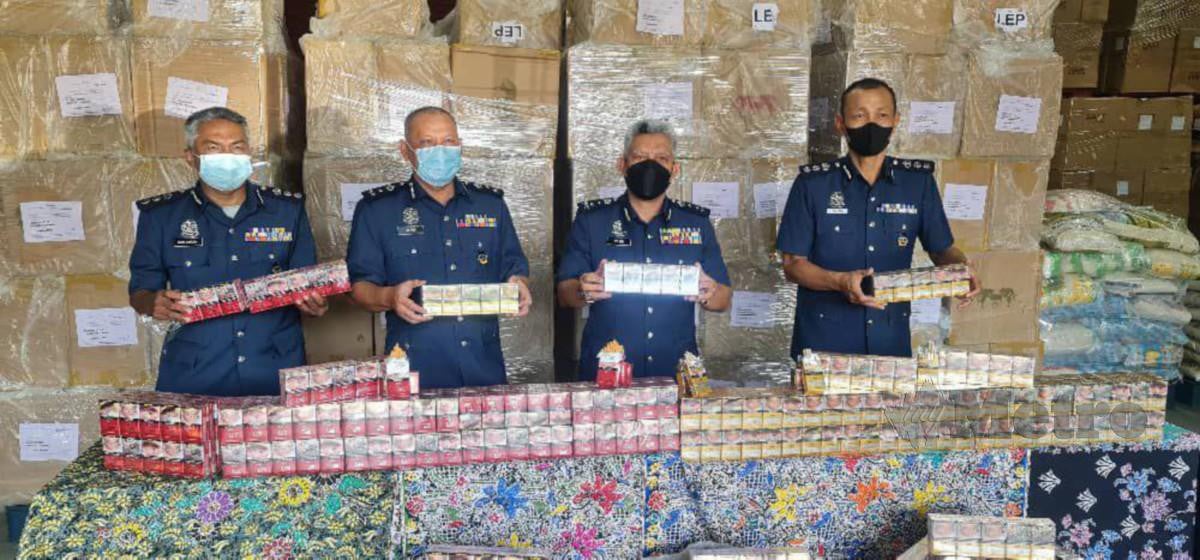 MOHD Nasir (dua dari kanan) menunjukkan sebahagian daripada hampir enam juta batang rokok seludup yang dirampas dalam tiga serbuan. FOTO ihsan JKDM