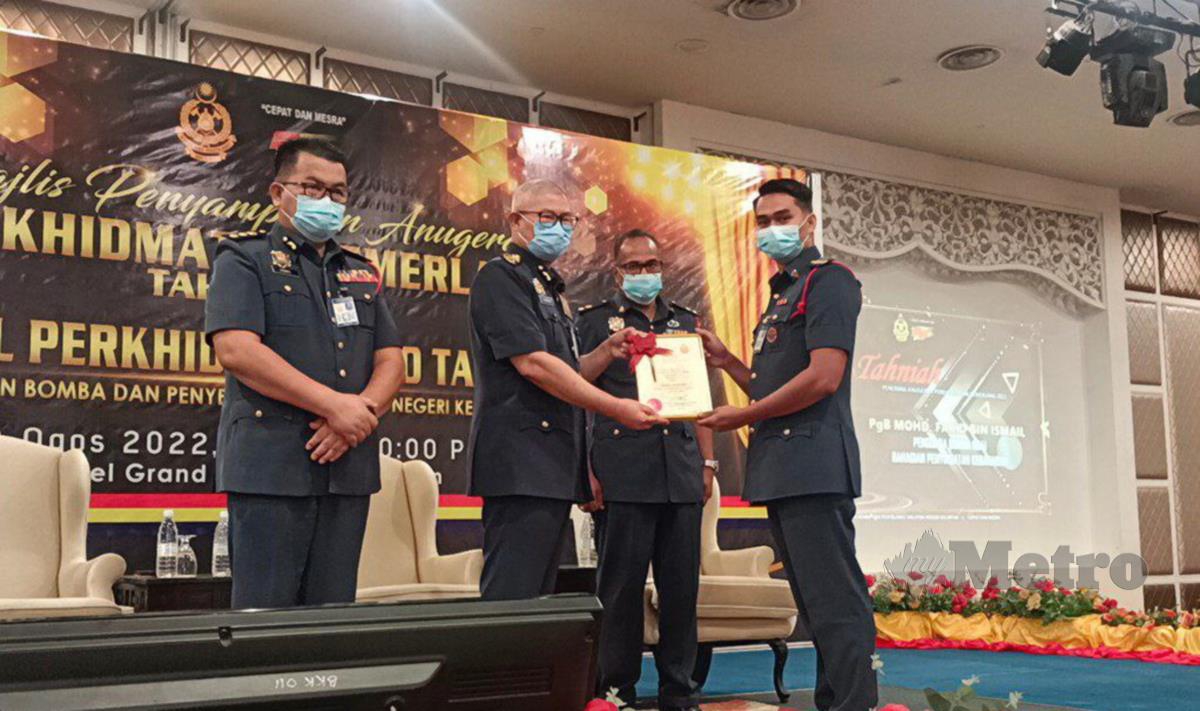 Hamdan Wahid menyampaikan sijil APC 2021 kepada pegawai dan anggota JBPM Kelantan, di sini. FOTO SITI ROHANA IDRIS