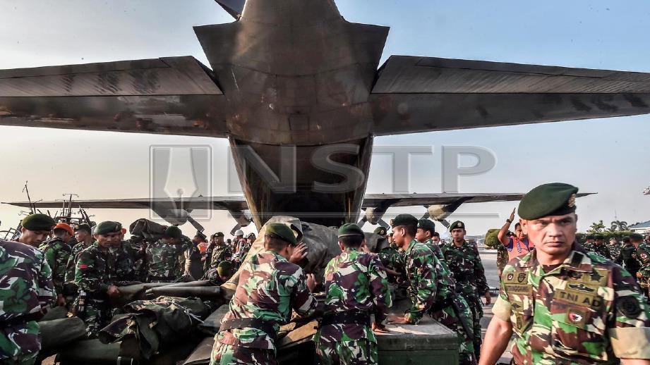 Tentera Indonesia membawa anggota ke tempat bencana. FOTO Reuters 