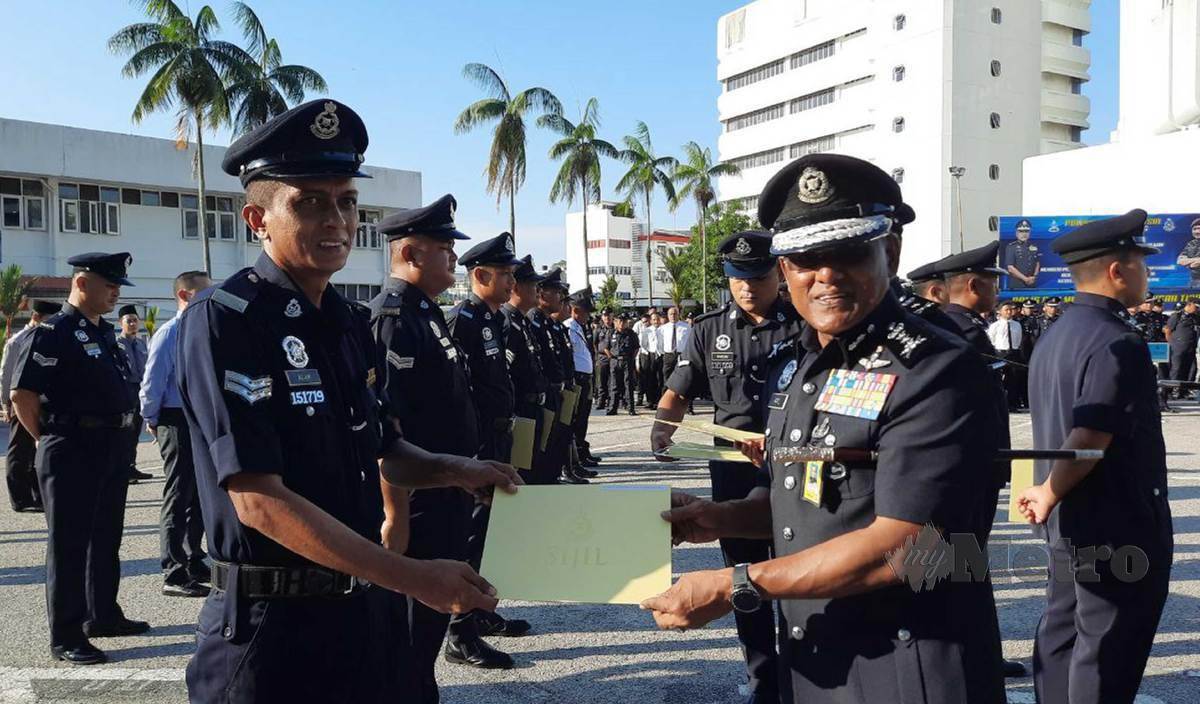 RAMLI (kanan) menyampaikan penghargaan kepada penerima pada Majlis Perhimpunan Bulanan Polis Pahang bagi Jun 2022 di Kuantan. FOTO Asrol Awang