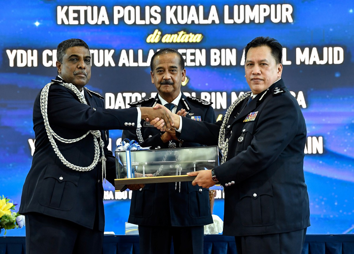 RAZARUDIN (tengah) menyaksikan penyerahan tongkat kuasa tugas jawatan Ketua Polis Kuala Lumpur antara Datuk Allaudeen Abdul Majid (kiri) kepada Datuk Rusdi Mohd Isa (kanan). FOTO Bernama 