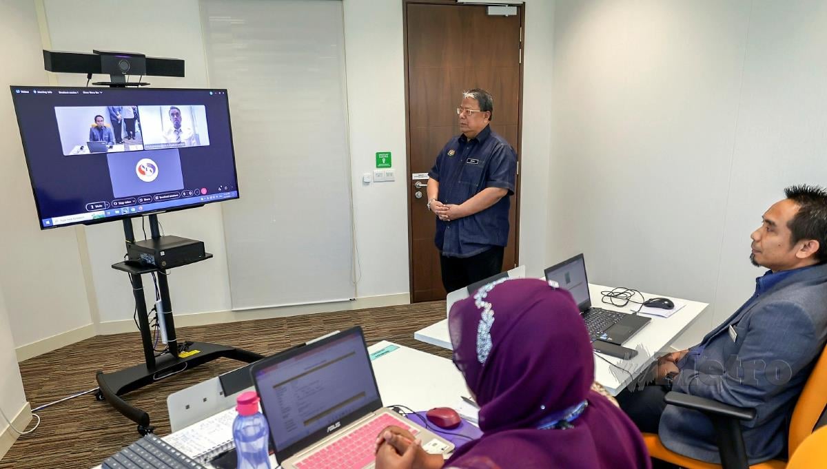 Zainal Rahim Seman (berdiri) melihat proses temuduga secara dalam talian di Pusat Temu Duga SPA hari ini. FOTO BERNAMA