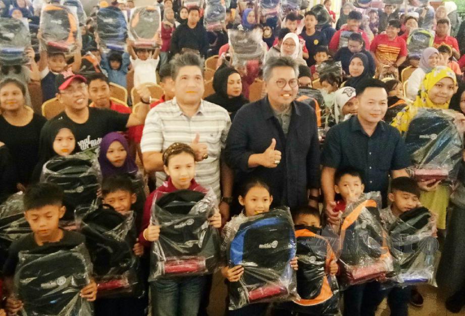 PENGURUS Besar Tabung Baitulmal Sarawak (TBS), Datuk Abang Mohd Shibli Abang Mohd Nailie (tiga kanan) bergambar bersama murid yang menerima bantuan 'Jom Kembali Ke Sekolah di Majma Mall,Kuching, hari ini.