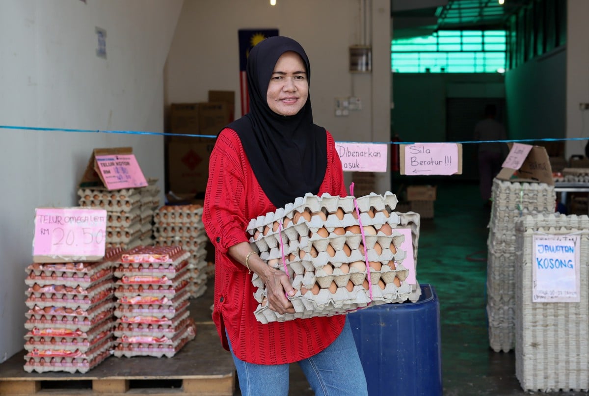 PENIAGA kuih, Nor Zuraini Abdul Aziz memperoleh bekalan telur ayam di sebuah kedai pemborong telur untuk perniagaan kuih-muihnya ketika tinjauan hari ini. FOTO Bernama 