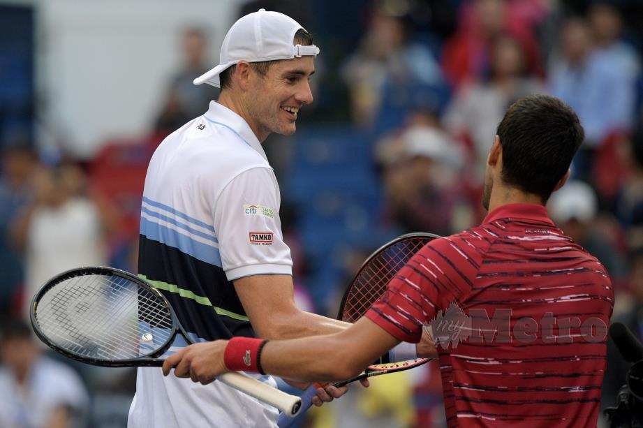 DJOKOVIC bersalaman dengan   Isner  selepas tamat perlawanan di Shanghai. - FOTO AFP 