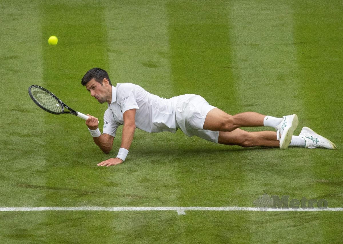JUARA dunia, Novak Djokovic tergelincir di atas rumput ketika membalas pukulan pemain Britain, Jack Draper di pusingan pertama Wimbledon, hari ini. FOTO AFP