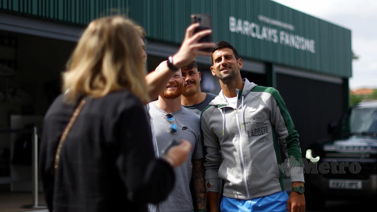 DJOKOVIC (kanan) berswafoto dengan peminat sebelum memulakan cabaran di Wimbledon. FOTO REUTERS 