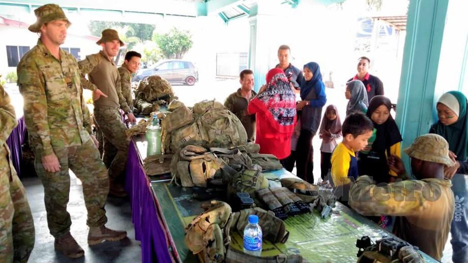 TENTERA Darat Australia menunjukkan peralatan digunakan kepada murid SK Kem Pengkalan Chepa sempena Program Jiwa Murni bersama ATM. FOTO Siti Rohana Idris