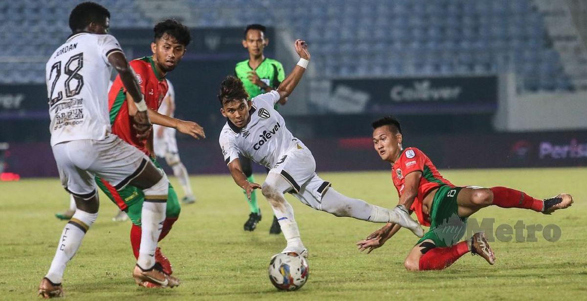 PEMAIN TFC, Muhammad Syafik (tengah) diasak  pemain Kelantan United FC, Khairul Azrin (kanan) pada perlawanan Liga Super di Stadium Sultan Mizan Zainal Abidin. FOTO GHAZALI KORI