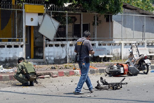 Anggota skuad pemusnah bom Thailand memeriksa lokasi serangan bom motosikal di Narathiwat. - Foto AFP