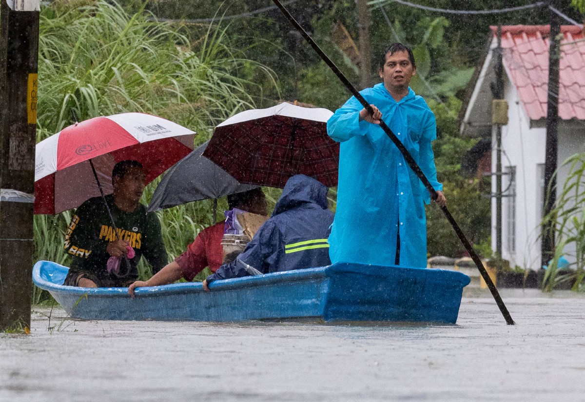PENDUDUK Kampung Wakaf Stan menaiki perahu meredah banjir untuk berpindah ke Pusat Pemindahan Sementara (PPS). FOTO Bernama 
