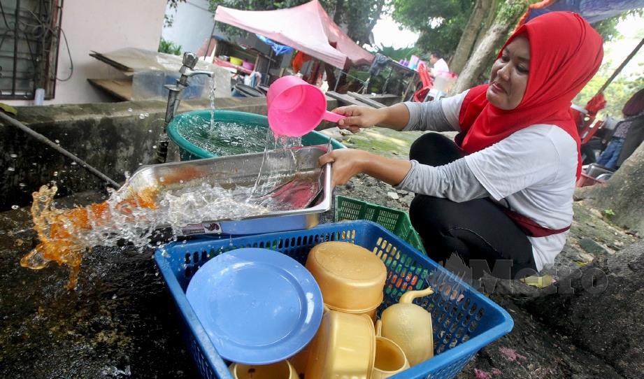 PEKERJA gerai makan di Pantai Dalam, Kuala Lumpur mencuci peralatan memasak, hari ini. FOTO Intan Nur Elliana Zakaria.