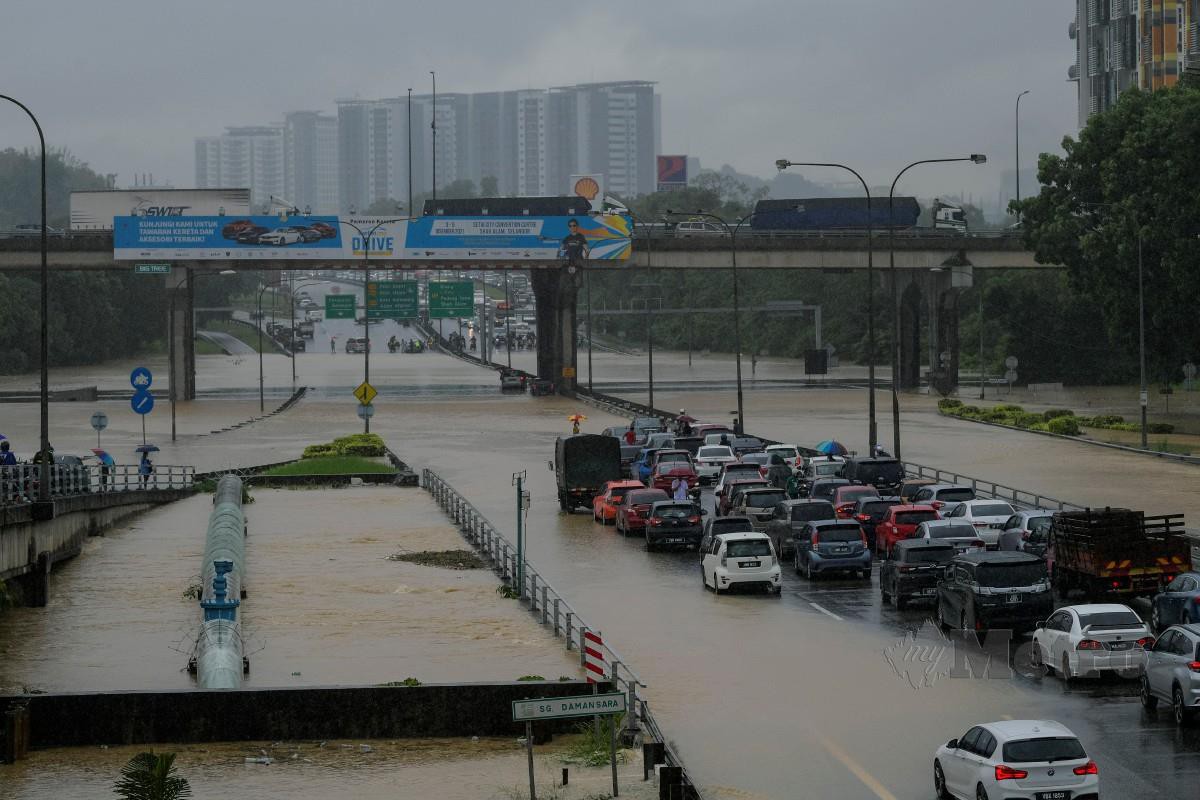 SUASANA di Batu 3, Lebuhraya Persekutuan yang ditenggelami air sehingga tidak boleh dilalui oleh kenderaan susulan limpahan air dari Sungai Damansara. FOTO Bernama 