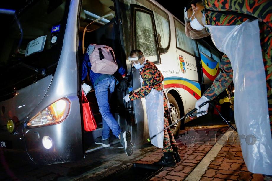 ANGGOTA Bomba membuat semburan nyah kuman pada kasut pelajar ketika menaiki bas pada tinjauan pelajar IPT dihantar pulang untuk Zon Utara di Universiti Kebangsaan Malaysia, Bangi. FOTO Aizuddin Saad
