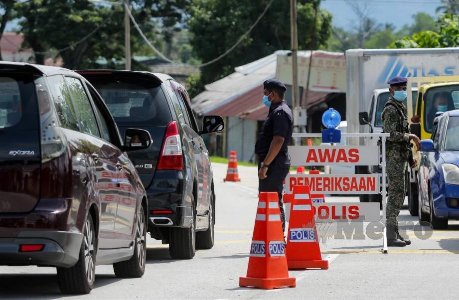 ANGGOTA polis bersama tentera membuat pemeriksaan setiap kenderaan yang melalui sekatan jalan raya di Beranang, Semenyih. FOTO Aizuddin Saad.