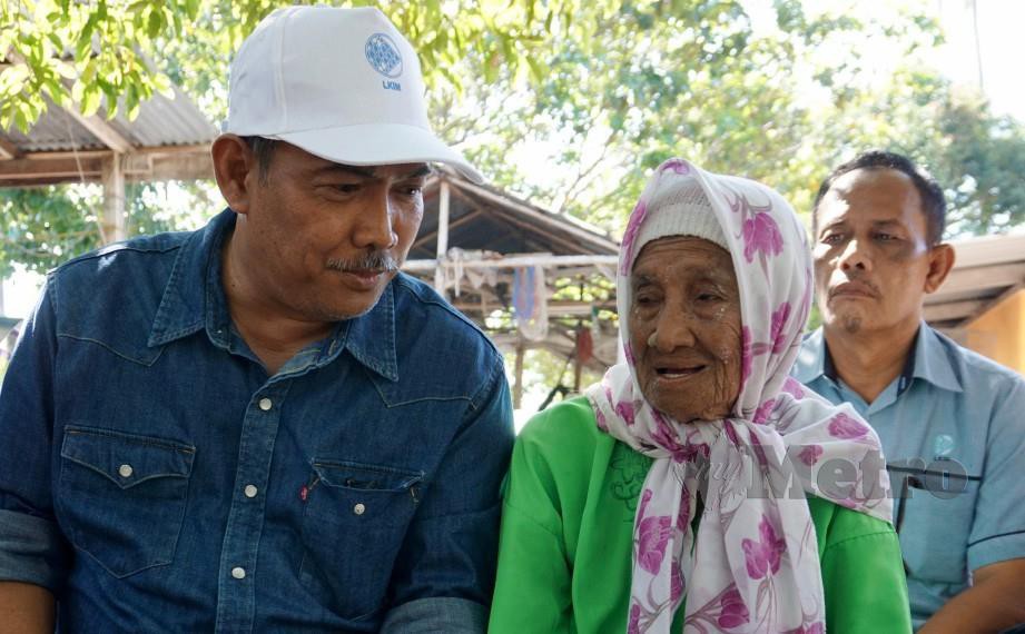 JAMALUDIN bertanya khabar Tok Pora ketika ditemui di rumahnya di Kampung Telok Berembang, Pulau Tuba. FOTO Bernama