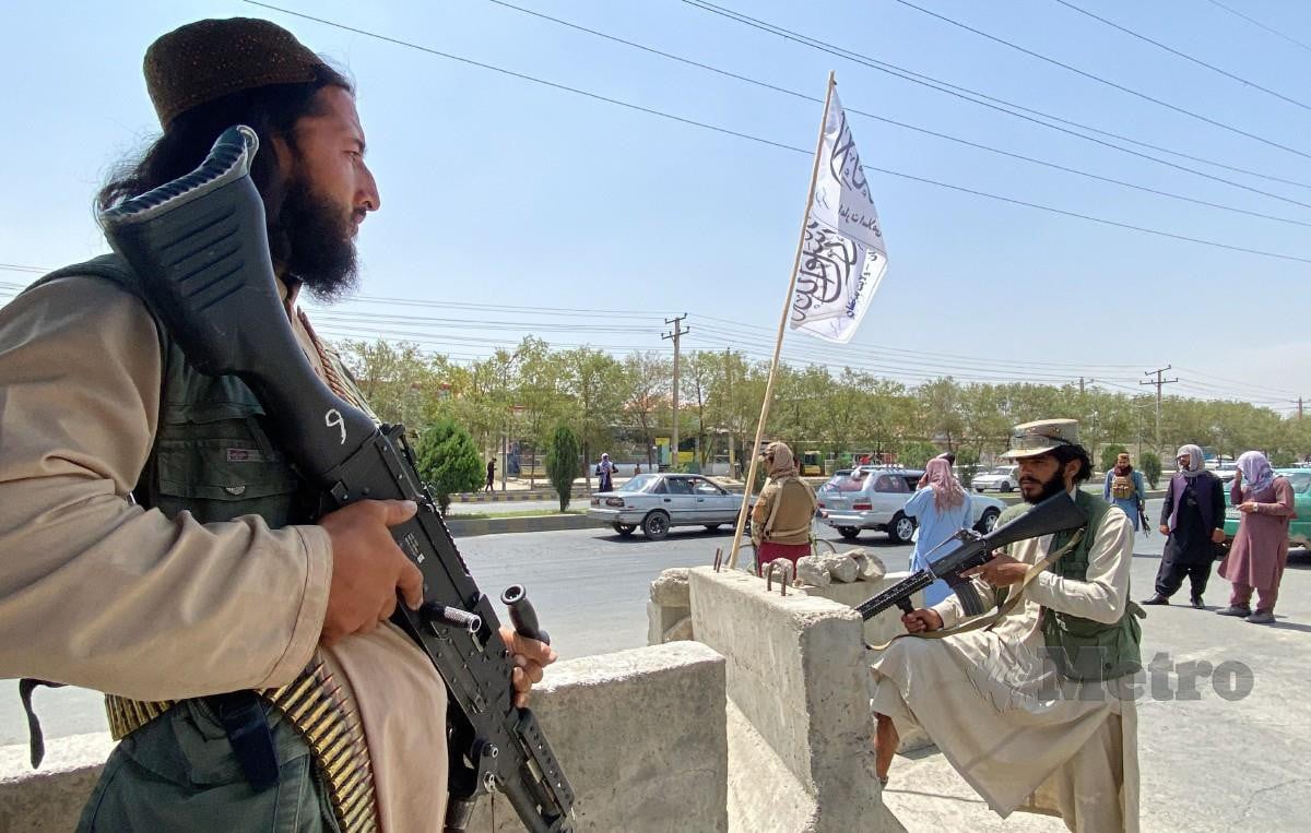 PEJUANG Taliban mengawal pintu masuk Kementerian Dalam Negeri di Kabul. FOTO AFP 