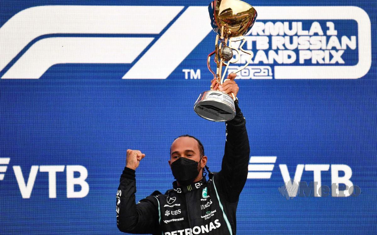 HAMILTON meraikan kejuaraan ke-100 di atas podium. FOTO AFP