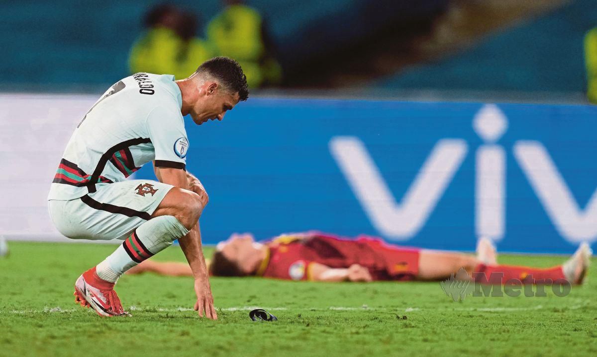 PENYERANG Portugal, Cristiano Ronaldo tertunduk kecewa selepas tersingkir daripada Euro 2020 berikutan tewas 0-1 di tangan Belgium, semalam. FOTO AFP