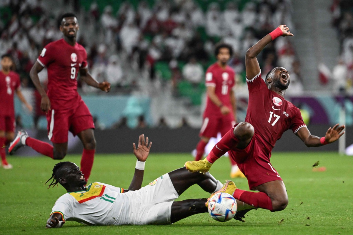 Pemain Qatar, Ismaiel Mohammed (kanan) dihalang pemain Senegal pada aksi Kumpulan A. FOTO AFP