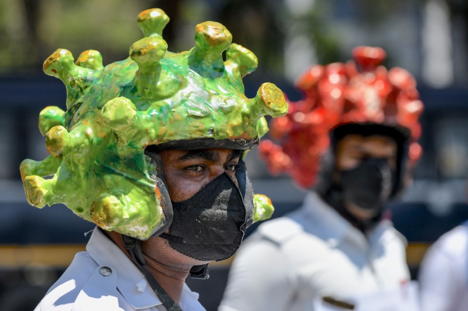 POLIS trafik di Bangalore, India memakai topi keleder bertemakan Covid-19. FOTO AFP 