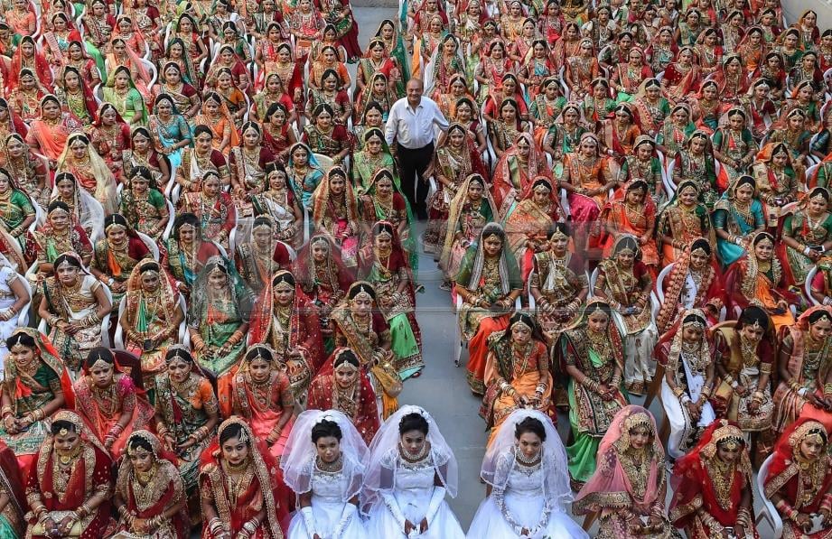 MAHESH (tengah) bergambar bersama pengantin perempuan dalam majlis perkahwinan besar-besaran di Surat, India, semalam. Foto AFP