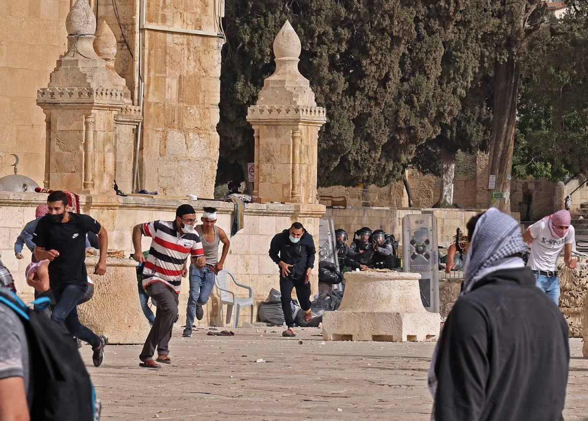 PENDUDUK Palestin melarikan diri ketika pertempuran dengan pasukan keselamatan Israel di laman Masjid Al-Aqsa. FOTO AFP 