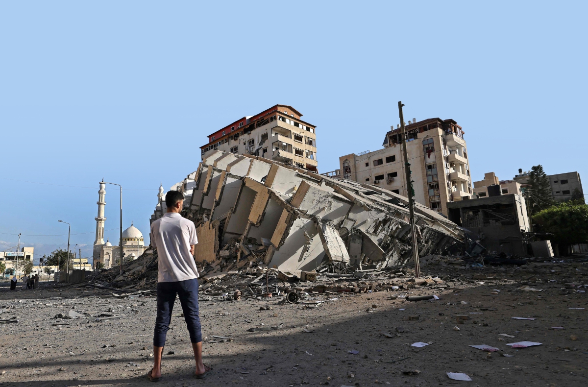 SEORANG pemuda Palestin melihat bangunan yang musnah dibedil dalam siri serangan udara Israel di sekitar Semenanjung Gaza. FOTO AFP