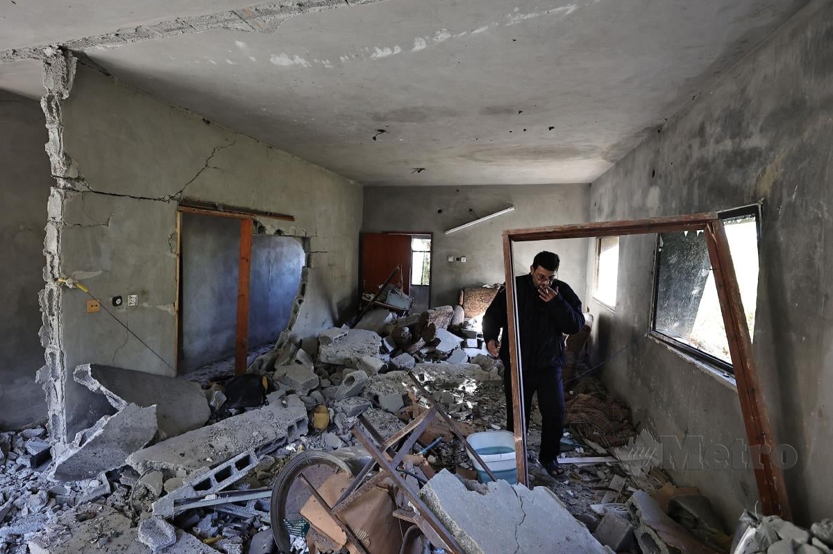 Seorang lelaki memeriksa kerosakan di sebuah rumah di kem pelarian di Tulkarm, tempat tentera Israel melakukan serbuan semalaman, pada 19 Januari 2024 di Tebing Barat yang diduduki, di tengah-tengah pertempuran berterusan antara Israel dan kumpulan militan Palestin Hamas di Gaza. FOTO AFP