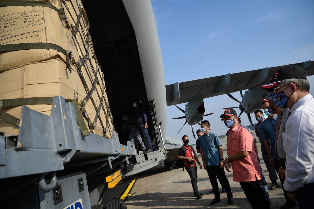MUHYIDDIN (tiga, kiri) dan Adham (kanan) ketika melakukan tinjauan untuk persiapan penghantaran keperluan kritikal Covid-19 ke Sabah di Pangkalan Udara Subang yang dikendalikan oleh TUDM hari ini. FOTO BERNAMA 