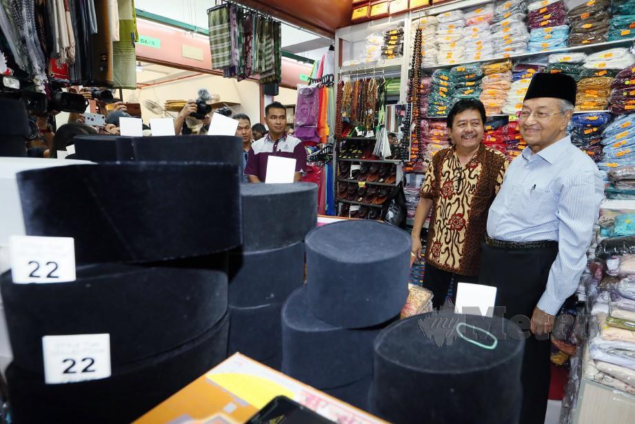 DR Mahathir memakai Songkok Gaya Tun yang dihasilkan oleh Sardi (dua dari kanan) ketika meluangkan masa membeli-belah di Kompleks Pekan Rabu. FOTO Amran Hamid 