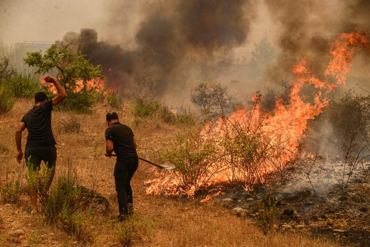 PENDUDUK memadam kebakaran di kawasan peusat peranginan Mediterranean yang terjejak akibat kebakaran hutan. FOTO AFP 