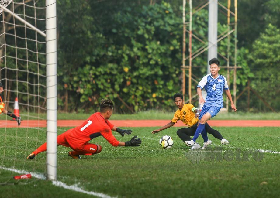 Pemain Malaysia, Muhammad Nabil Qayyum Zainuddin (tengah) melakukan rembatan ke arah gawang gol lawan.