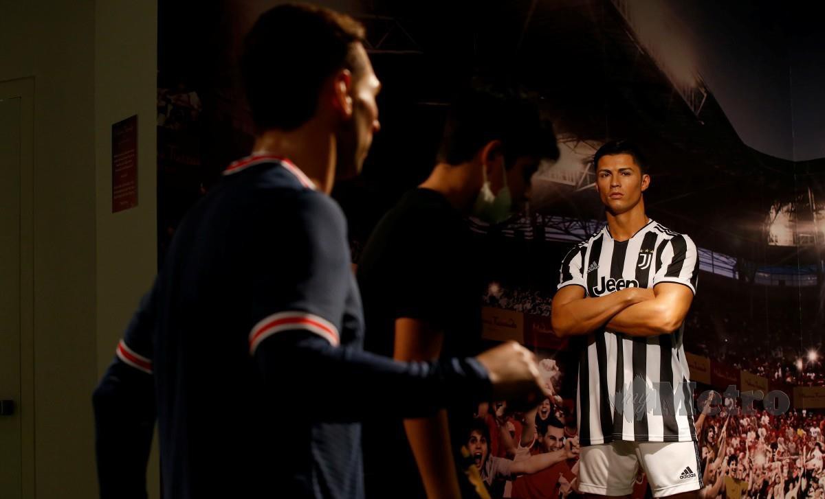 PATUNG lilin Ronaldo (kanan) masih lagi ‘memakai’ jersi pasukan lamanya iaitu Juventus. FOTO EPA