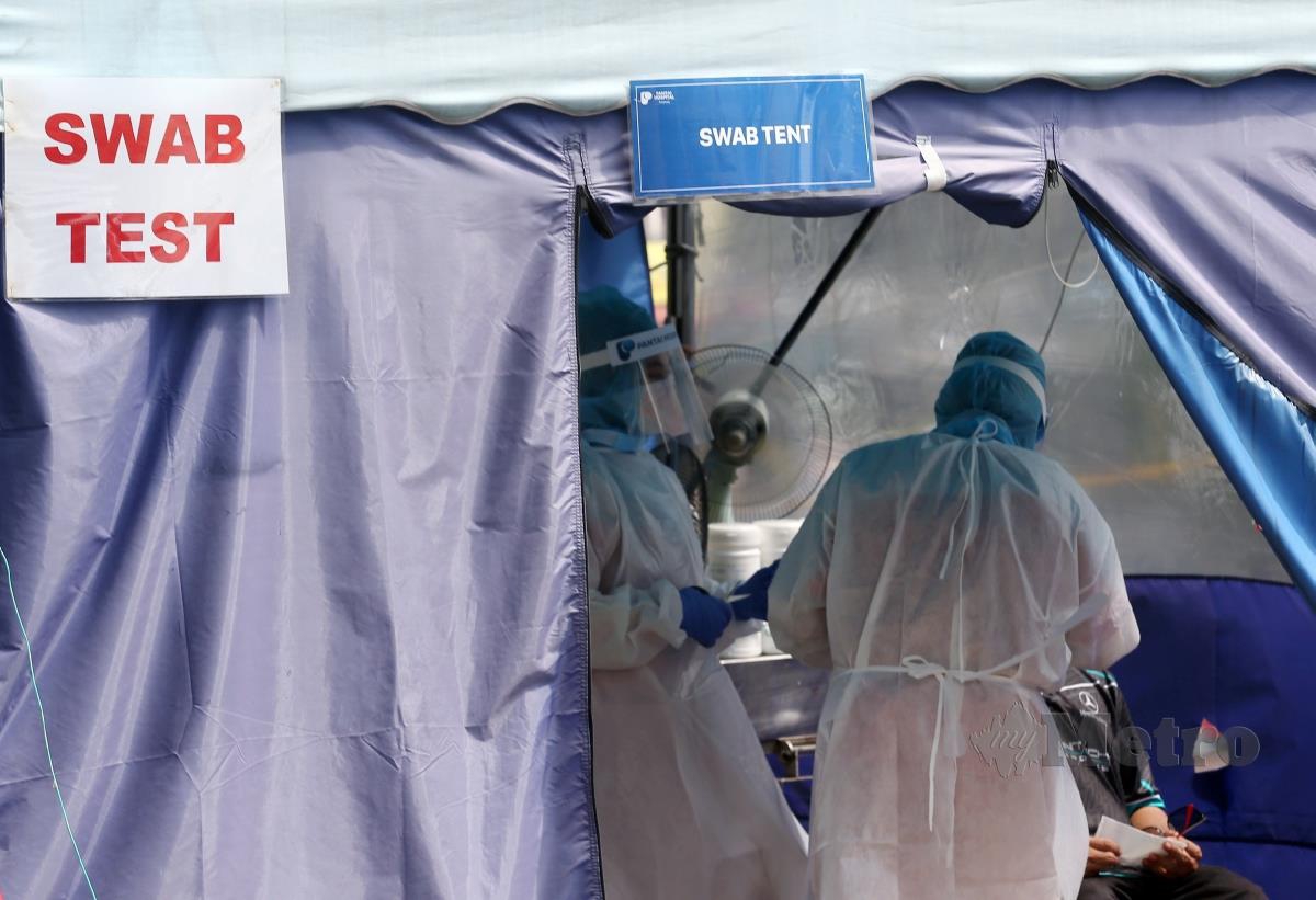 PETUGAS kesihatan membuat ujian saringan Covid-19 di hospital swasta di Ampang, hari ini. FOTO EIZAIRI SHAMSUDIN