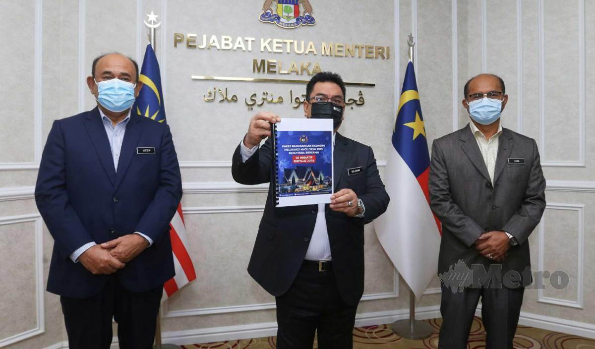 SULAIMAN (tengah) menunjukkan buku pelan Pakej Rangsangan Ekonomi Melakaku Maju Jaya 2021 sebanyak 60 inisiatif yang bernilai RM 174.53 juta selepas peruntusan khas yang disiarkan secara maya di Pejabat Ketua Menteri, Melaka. FOTO Syafeeq Ahmad