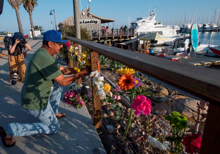 SEORANG lelaki meletakkan bunga bagi memperingati mangsa-mangsa kapal terbakar di luar pantai California yang telah meningkat kepada 25 orang. FOTO AFP