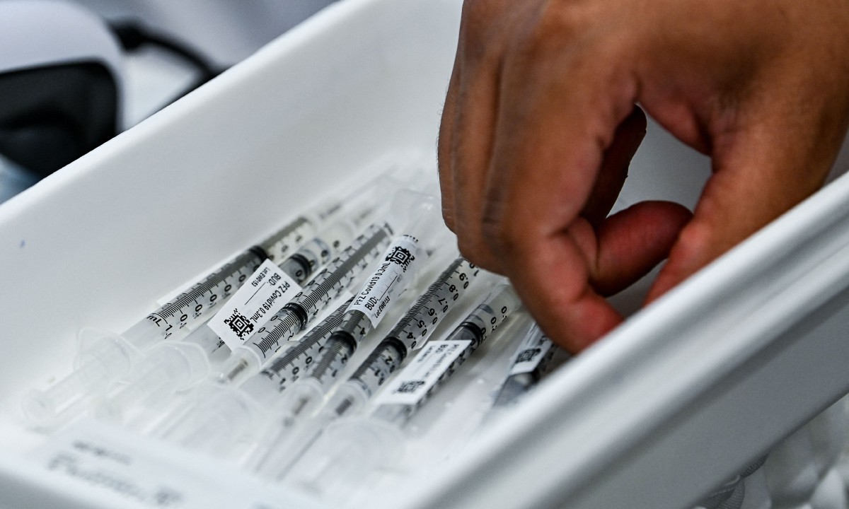 Petugas farmasi menyediakan vaksin Pfizer di Pusat Pemulihan di Miami. FOTO AFP